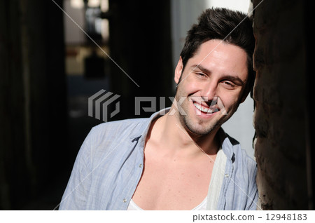 Portrait of young smiling man in urban background 12948183