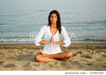 Pretty woman doing yoga on the beach Pretty woman doing yoga on the beach 12948399