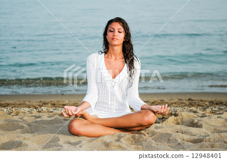Pretty woman doing yoga on the beach Pretty woman doing yoga on the beach 12948401