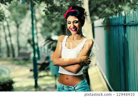 Pin-up girl. American style, in a garden Pin-up girl. American style, in a garden 12948410