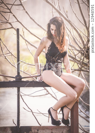 Sexy young woman in lingerie posing outdoor 12948591