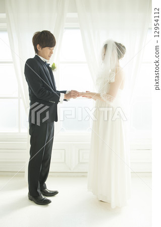 Bride and groom who exchanges rings 12954112