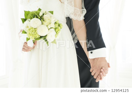 A bride and groom holding hands A bride and groom holding hands 12954125