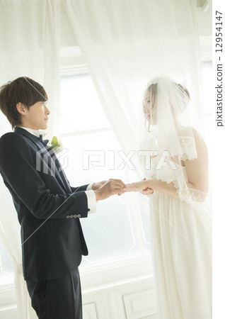 Bride and groom who exchanges rings 12954147