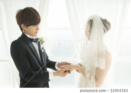 Bride and groom who exchanges rings 12954183
