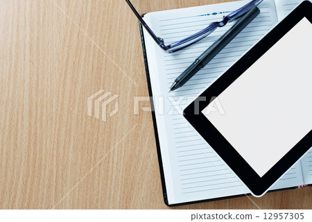 Modern tablet PC next to a classical open agenda 12957305