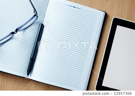 Modern tablet PC next to a classical open agenda 12957306