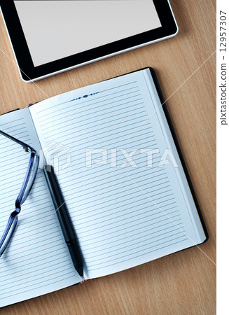 Modern tablet PC next to a classical open agenda Modern tablet PC next to a classical open agenda 12957307