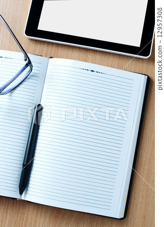 Modern tablet PC next to a classical open agenda Modern tablet PC next to a classical open agenda 12957308