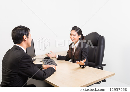 Two confident business people in the office discussing 12957968
