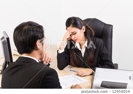 Two business people in serious discussion Two business people in serious discussion 12958054