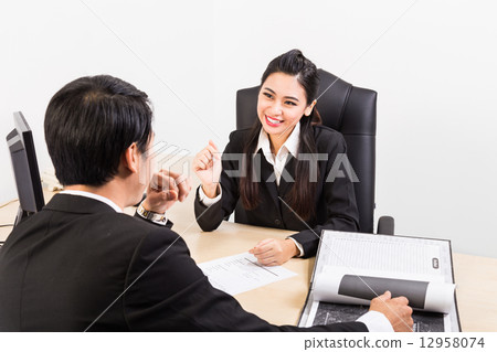 Two confident business people in the office discussing 12958074