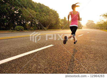 young fitness woman running at sunrise road 12964263