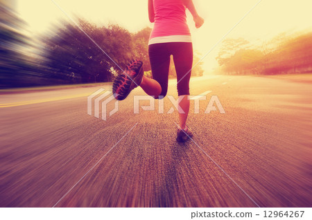 young fitness woman running at sunrise road 12964267