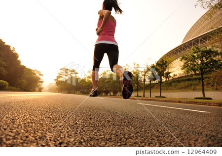 young fitness woman running at sunrise  12964409