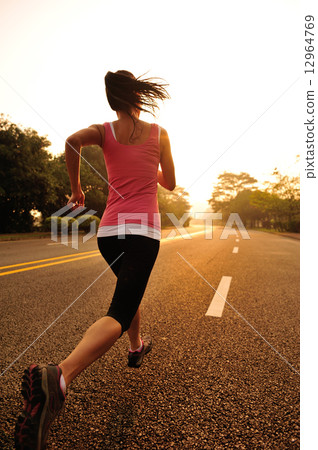 young fitness woman running at sunrise road 12964769