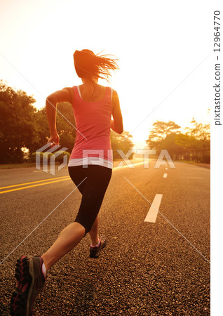 young fitness woman running at sunrise road 12964770