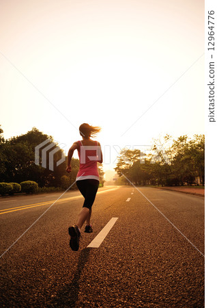 young fitness woman running at sunrise road 12964776