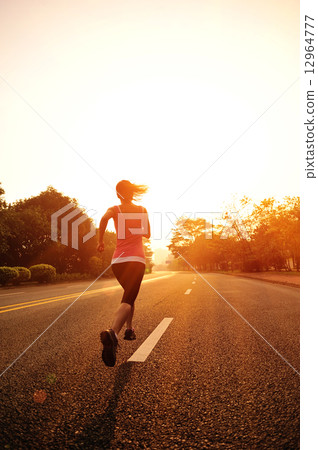 young fitness woman running at sunrise road 12964777