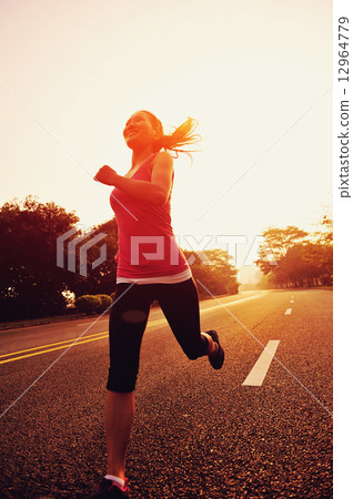 young fitness woman running at sunrise road 12964779