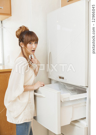 A young woman who opens a fridge A young woman who opens a fridge 12966845