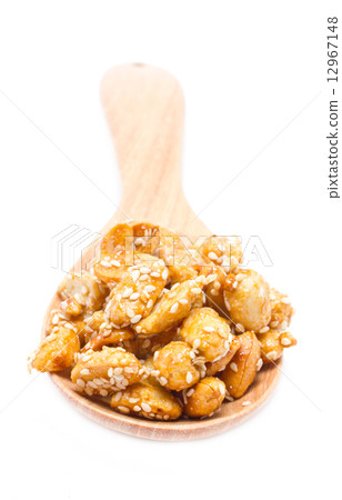 Crispy sugared nuts with wooden spoon isolated on white. Crispy sugared nuts with wooden spoon isolated on white. 12967148