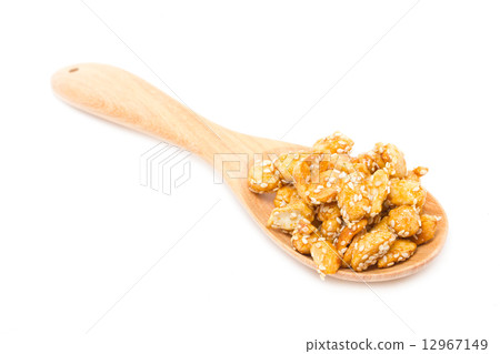 Crispy sugared nuts with wooden spoon isolated on white. Crispy sugared nuts with wooden spoon isolated on white. 12967149