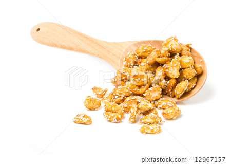 Crispy sugared nuts with wooden spoon isolated on white.  12967157