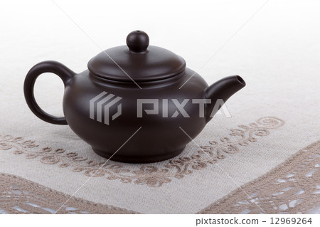 Traditional asian clay teapot with lace doily. Traditional asian clay teapot with lace doily. 12969264