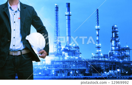 engineering man and safety helmet standing against oil refinery 12969992