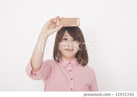 A woman taking a picture with her cell phone 12972350