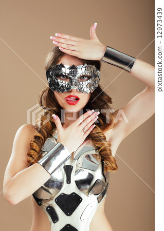 Futurism. Robotic Woman in Cosmic Mask and Metallic Stagy Costume Gesturing 12973439