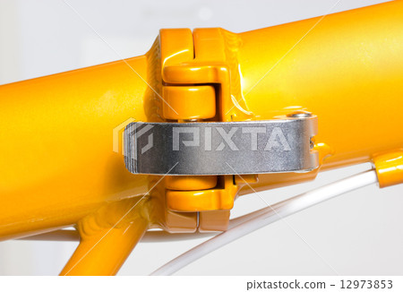 Close up of hinge at middle of frame of folding bicycle. Close up of hinge at middle of frame of folding bicycle. 12973853