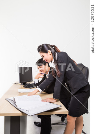 Two confident business people in the office discussing 12975531