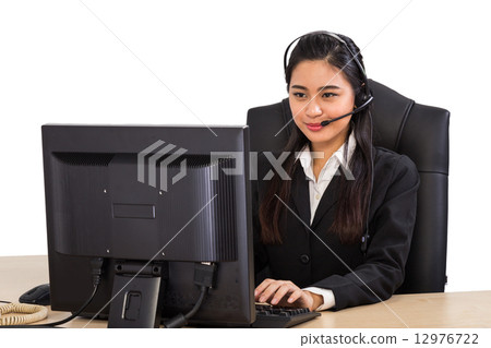 Friendly call center operator at her work station 12976722