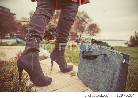 woman legs wearing boots and hand bag woman legs wearing boots and hand bag 12979294