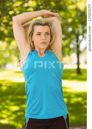 Fit blonde stretching in the park 12985074