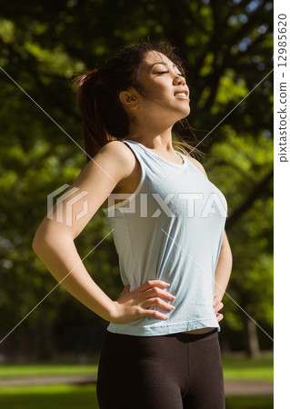 Side view of healthy woman standing in park Side view of healthy woman standing in park 12985620