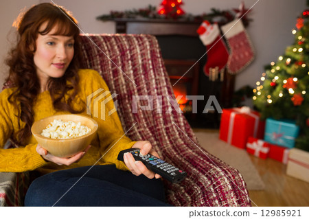 Pretty redhead watching television on couch at christmas Pretty redhead watching television on couch at christmas 12985921