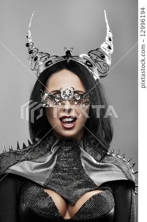 Fashion shot of a woman with metal horns and mask 12996194