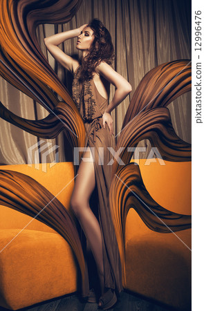 woman in long flying dress and yellow sofa 12996476