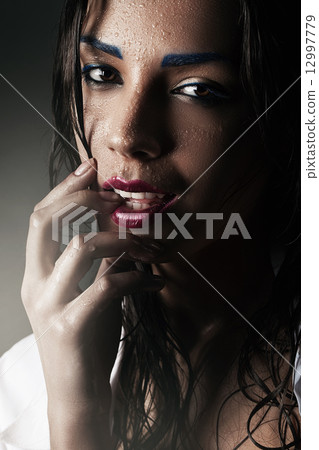 portrait of woman with fingers in mouth 12997779