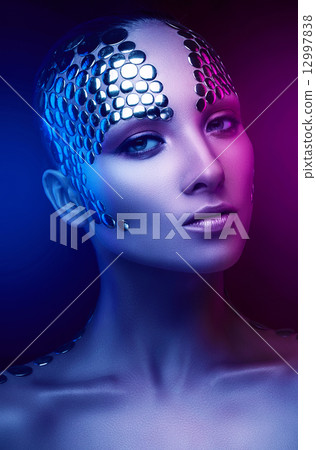 pretty woman with metal buttons on face 12997838