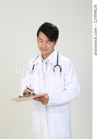 Male Doctor Writing Report on Clipboard Male Doctor Writing Report on Clipboard 12999626