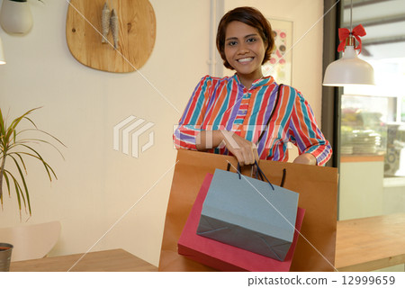 Woman taking a break after shopping 12999659