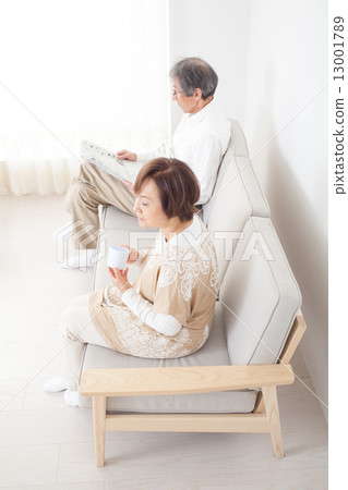 Senior couple sitting on the sofa and relaxing Senior couple sitting on the sofa and relaxing 13001789