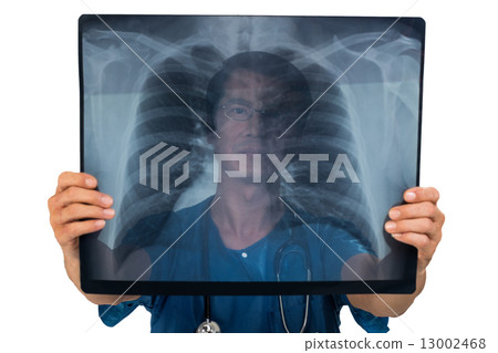 Surgeon examining x-ray film of a lung Surgeon examining x-ray film of a lung 13002468