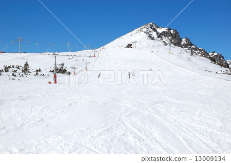 Skiers riding on a slope in Strbske Pleso ski resort, High Tatra 13009134