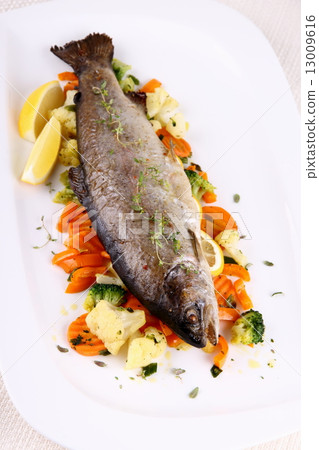 Grilled whole trout with vegetables and lemon Grilled whole trout with vegetables and lemon 13009616