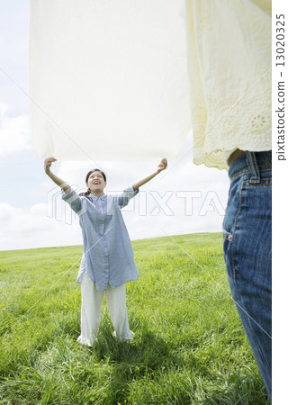一個女人在草地上傳播一張紙 13020325
